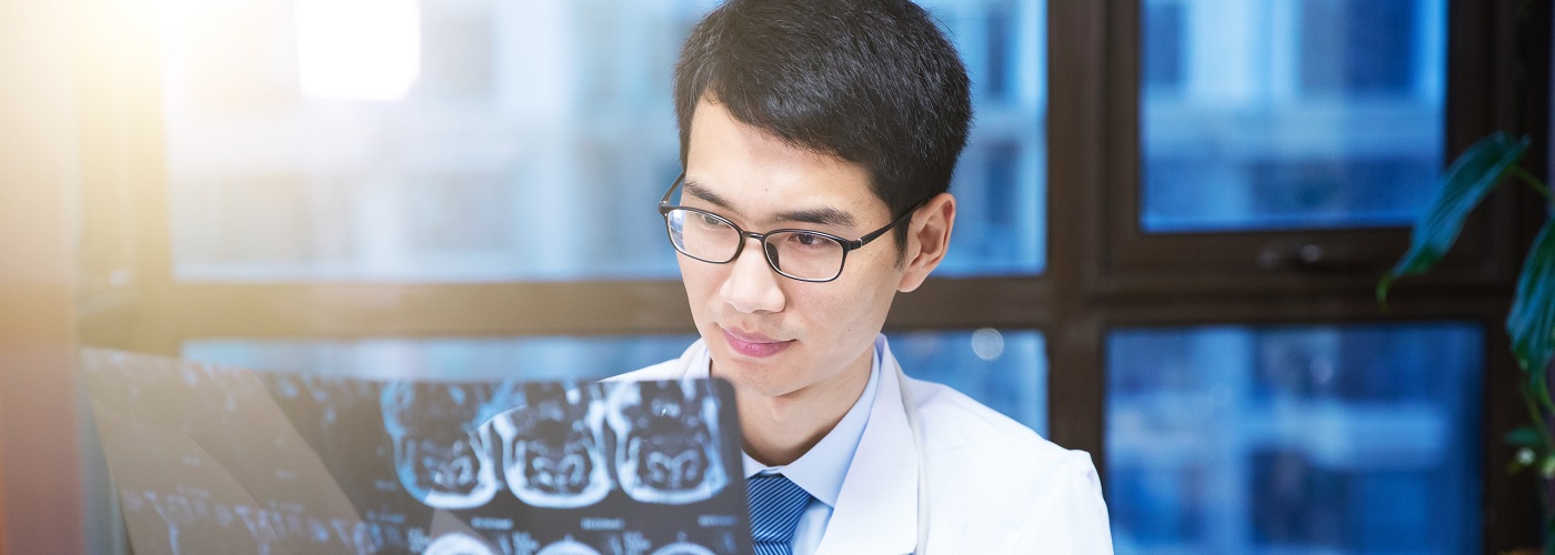 Neurologist carefully examining an X-ray 